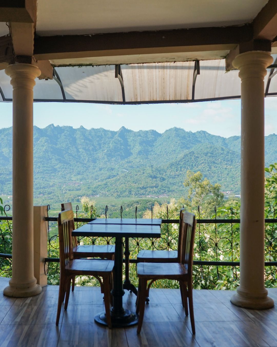 Singkong Keju & Kopi di Kedai Bukit Rhema: Cita Rasa Perbukitan Menoreh 2 Meja dan kursi di lantai 2 Kedai Bukit Rhema menghadap Perbukitan Menoreh